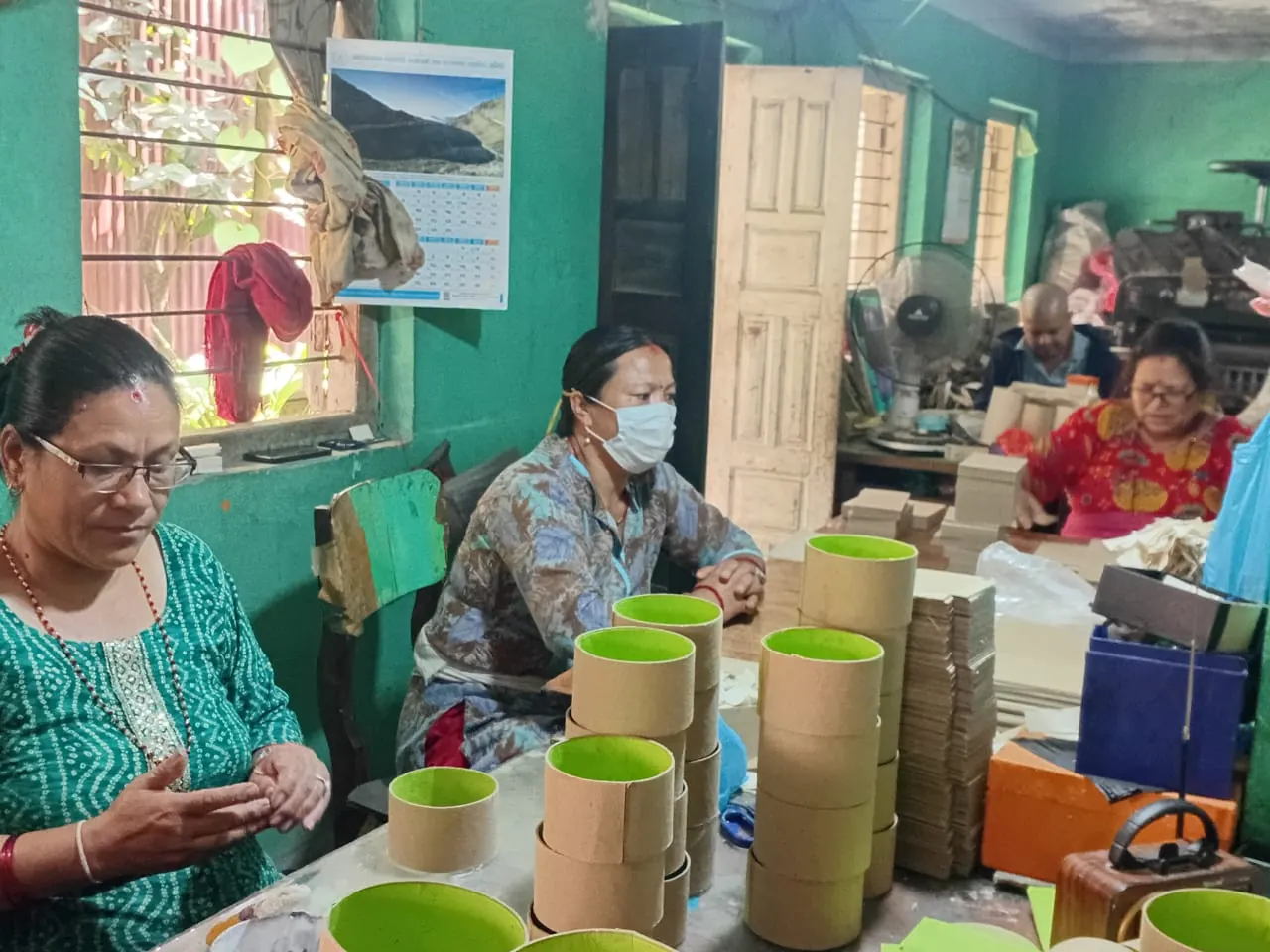 Yak & Yeti artisans at the workshop bench with lokta-covered boxes and cylinders